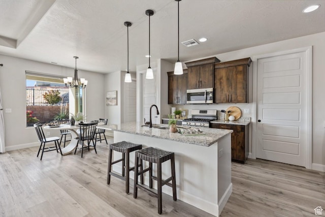 1867 W Grapevine, Hurricane, UT 84737 - kitchen with appliances with stainless steel finishes, light wood-type flooring, dark brown cabinets, a sink, and baseboards