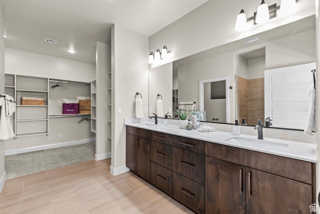 1867 W Grapevine, Hurricane, UT 84737 - bathroom with a spacious closet, double vanity, wood finished floors, baseboards, and tiled shower