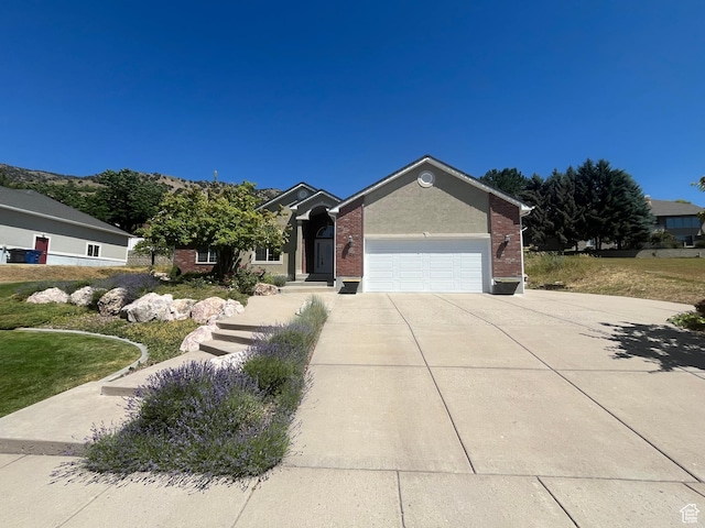240 Bugle Way, Providence, UT 84332 - view of front facade with concrete driveway, an attached garage, and brick siding