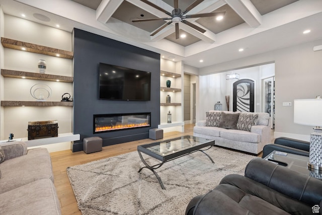 living room featuring coffered ceiling, a ceiling fan, wood finished floors, built in features, and beamed ceiling