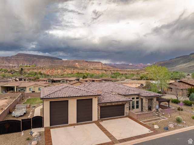 view of front of property with stucco siding, a gate, a garage, and a mountain view