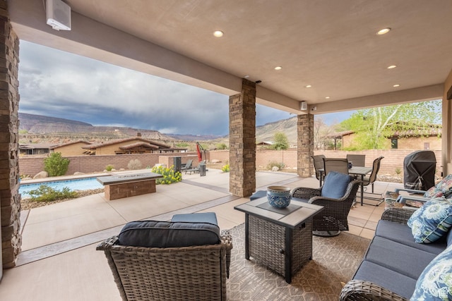 view of patio with a fenced backyard, a fenced in pool, a mountain view, and an outdoor living space