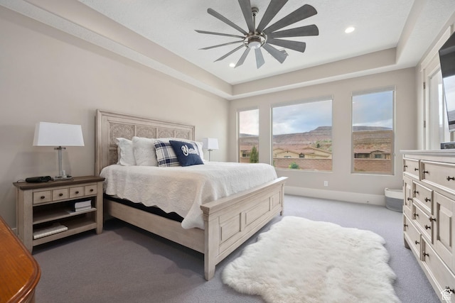 bedroom featuring recessed lighting, a raised ceiling, multiple windows, and light carpet