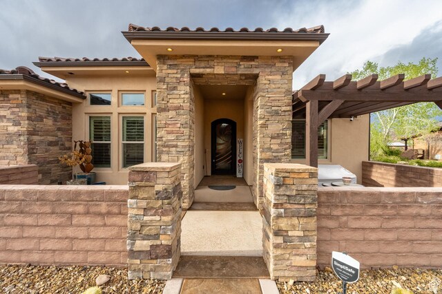doorway to property featuring stucco siding and stone siding
