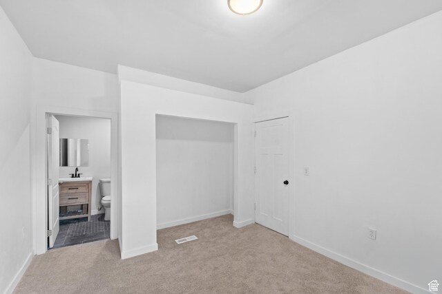2814 S 9100 W, Magna, UT 84044 - unfurnished bedroom with a sink, carpet floors, baseboards, connected bathroom, and a closet