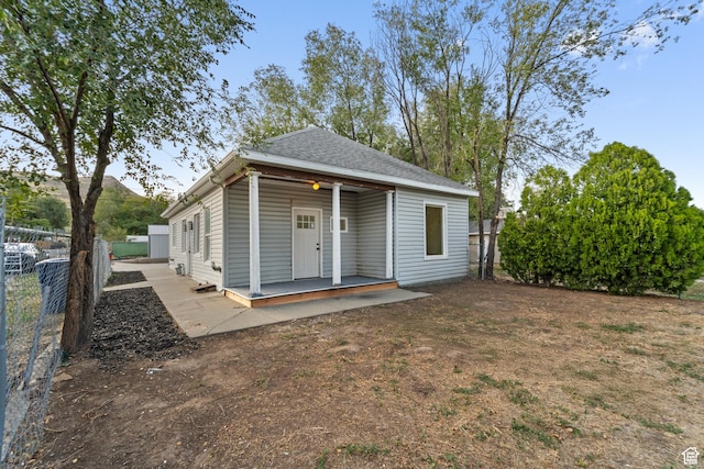 view of front of home featuring roof with shingles and fence