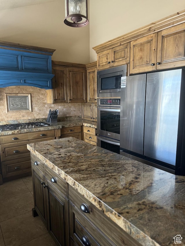 120 E Deseret Cir, Grantsville, UT 84029 - kitchen with appliances with stainless steel finishes, backsplash, dark stone counters, and dark tile patterned flooring