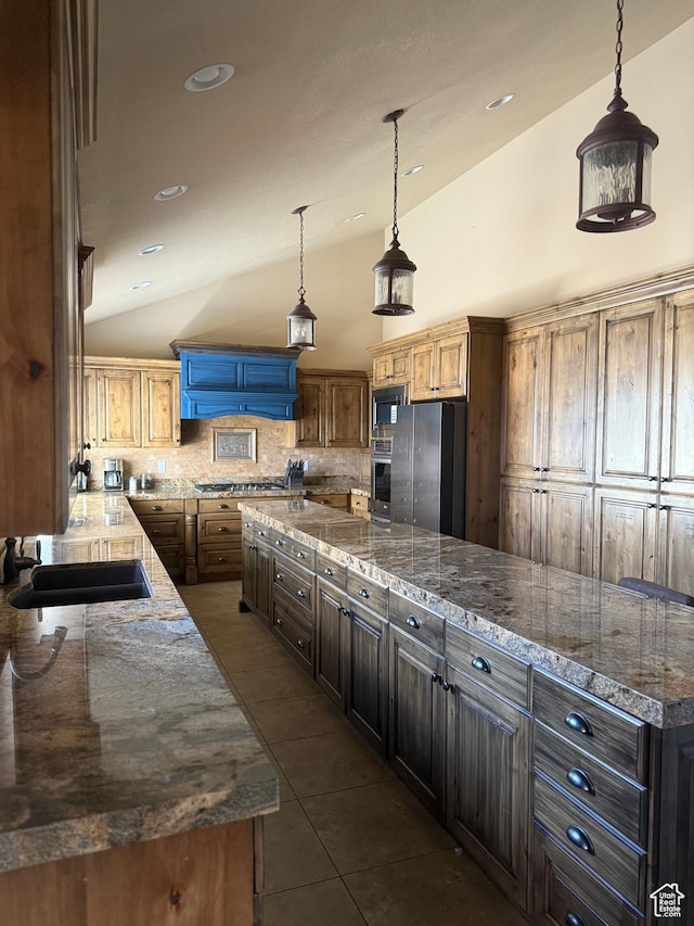 120 E Deseret Cir, Grantsville, UT 84029 - kitchen with appliances with stainless steel finishes, vaulted ceiling, a sink, tasteful backsplash, and dark tile patterned flooring