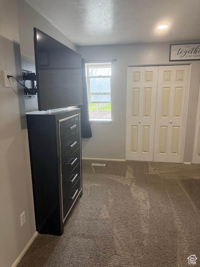 120 E Deseret Cir, Grantsville, UT 84029 - unfurnished bedroom with dark colored carpet, baseboards, a closet, and a textured ceiling
