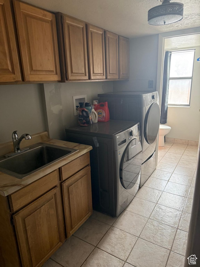 120 E Deseret Cir, Grantsville, UT 84029 - washroom featuring washing machine and dryer, light tile patterned flooring, cabinet space, and a textured ceiling