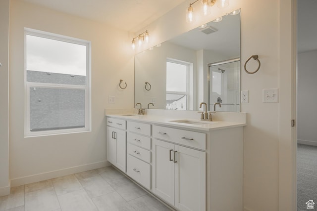 bathroom featuring double vanity, a sink, baseboards, and a shower stall