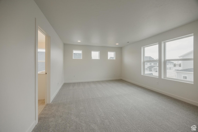 spare room with baseboards, light colored carpet, and recessed lighting