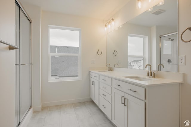 bathroom featuring visible vents, a sink, and a shower stall