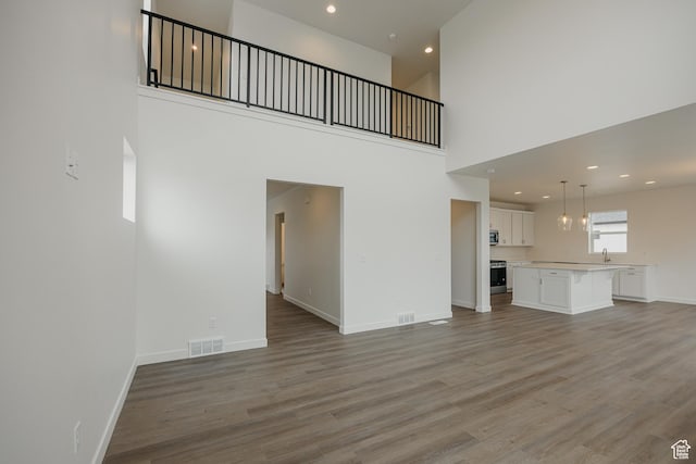 unfurnished living room featuring light wood-type flooring, baseboards, and visible vents