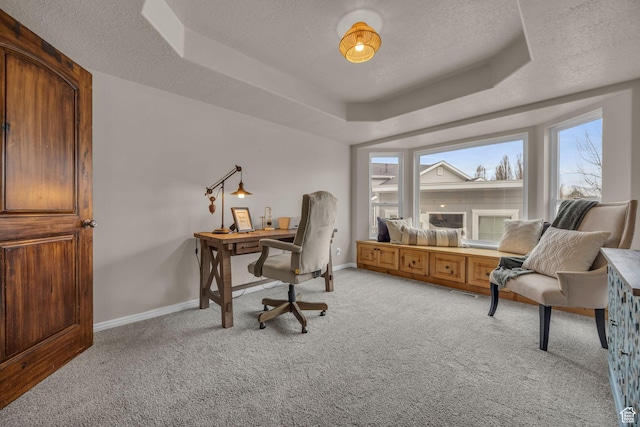 office with a raised ceiling, baseboards, light colored carpet, and a textured ceiling