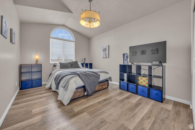 bedroom with baseboards, vaulted ceiling, and wood finished floors
