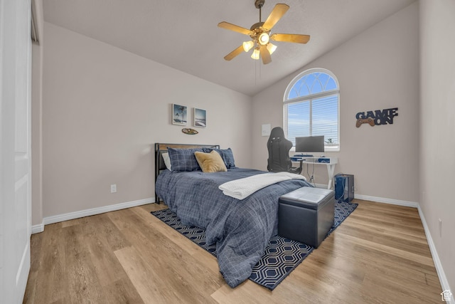 bedroom with a ceiling fan, baseboards, vaulted ceiling, and wood finished floors