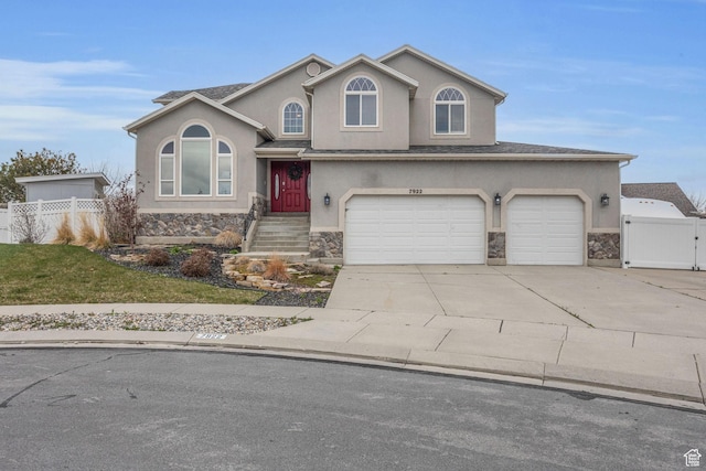 view of front facade featuring stone siding, fence, and stucco siding