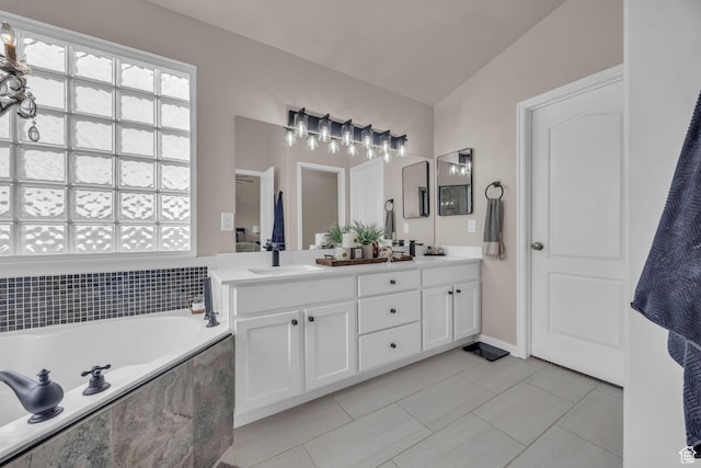 bathroom with double vanity, a bath, a sink, and tile patterned floors