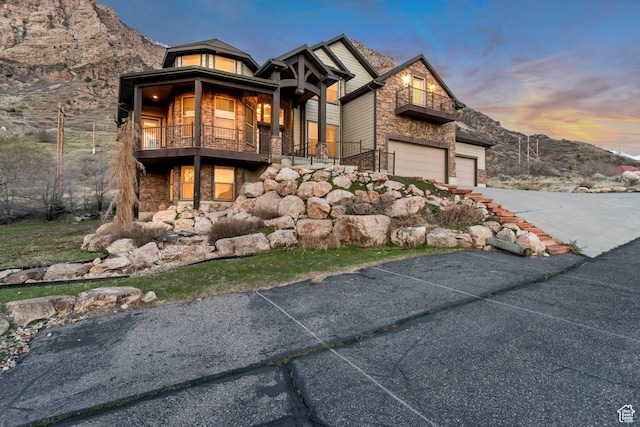 692 N Harrison Blvd, Ogden, UT 84404 - craftsman-style home with a balcony, stone siding, asphalt driveway, and a garage