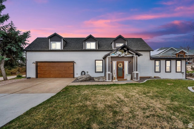 modern farmhouse with a lawn, roof with shingles, an attached garage, and concrete driveway