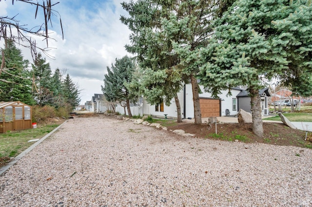 3225 N 1000 W, Pleasant View, UT 84414 - exterior space featuring an outdoor structure, gravel driveway, and a greenhouse