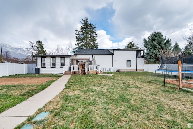 3225 N 1000 W, Pleasant View, UT 84414 - view of front of home featuring a trampoline, a deck, a front yard, and a fenced backyard