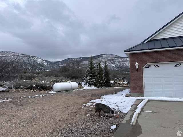 28848 N 11170 E, Milburn, UT 84629 - snow covered property featuring brick siding, a garage, and a mountain view