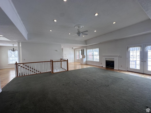 28848 N 11170 E, Milburn, UT 84629 - unfurnished living room featuring a high end fireplace, wood finished floors, recessed lighting, a raised ceiling, and ceiling fan with notable chandelier
