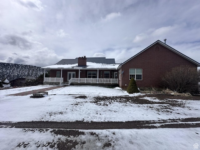 28848 N 11170 E, Milburn, UT 84629 - snow covered rear of property with a chimney, brick siding, a porch, and metal roof