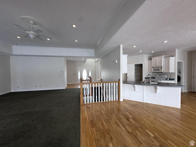 28848 N 11170 E, Milburn, UT 84629 - kitchen with white cabinetry, a kitchen bar, open floor plan, ceiling fan, and white microwave