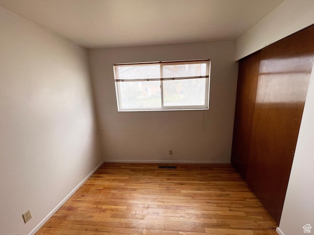 unfurnished bedroom with baseboards and light wood-style flooring