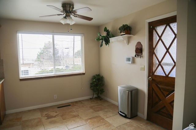 entryway featuring baseboards and ceiling fan