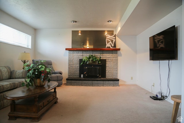 living area featuring baseboards, a fireplace, and carpet flooring