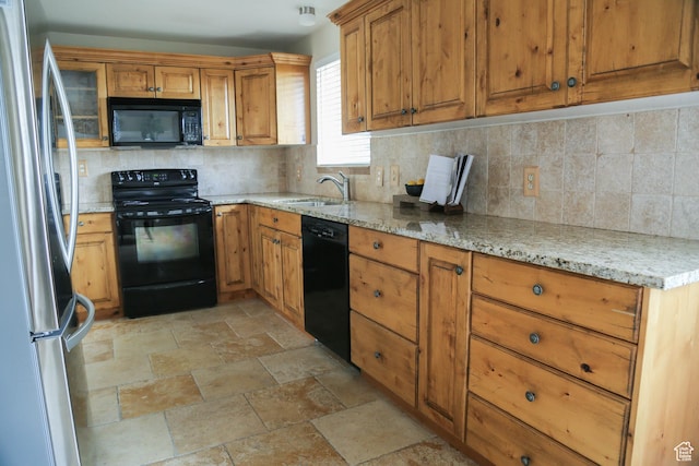 kitchen with a sink, decorative backsplash, black appliances, and brown cabinets
