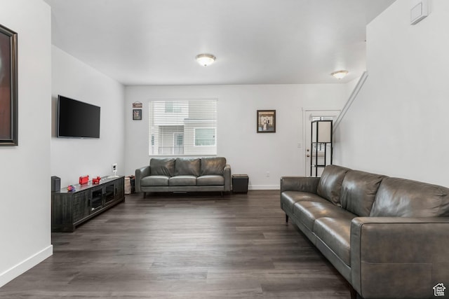 living room featuring baseboards and dark wood finished floors