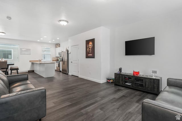 living area featuring baseboards, recessed lighting, and dark wood-type flooring