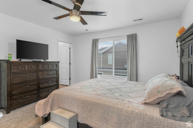 bedroom featuring visible vents, a ceiling fan, and light carpet