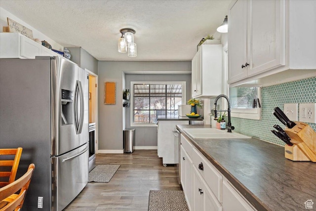 1335 Swan St, Ogden, UT 84401 - kitchen featuring white cabinets, stainless steel fridge, and dark countertops