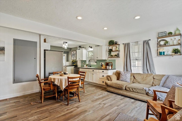 1335 Swan St, Ogden, UT 84401 - living room featuring light wood-type flooring, baseboards, recessed lighting, and a textured ceiling