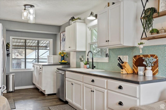 1335 Swan St, Ogden, UT 84401 - kitchen featuring dark countertops, a sink, dishwasher, white cabinetry, and dark wood-style floors