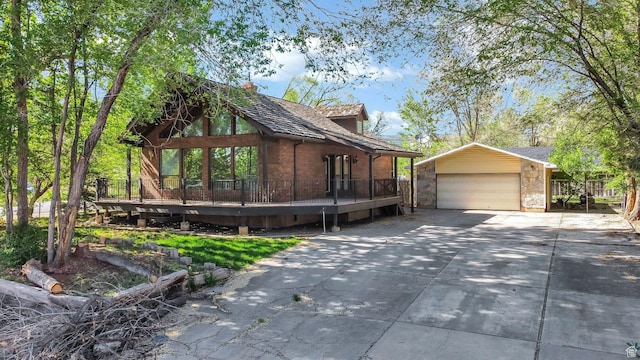 605 E 400 N, Richfield, UT 84701 - view of side of property featuring an outdoor structure, a wooden deck, concrete driveway, and stone siding