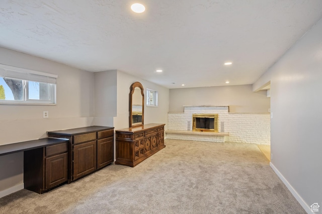 interior space with light colored carpet, baseboards, a brick fireplace, and recessed lighting
