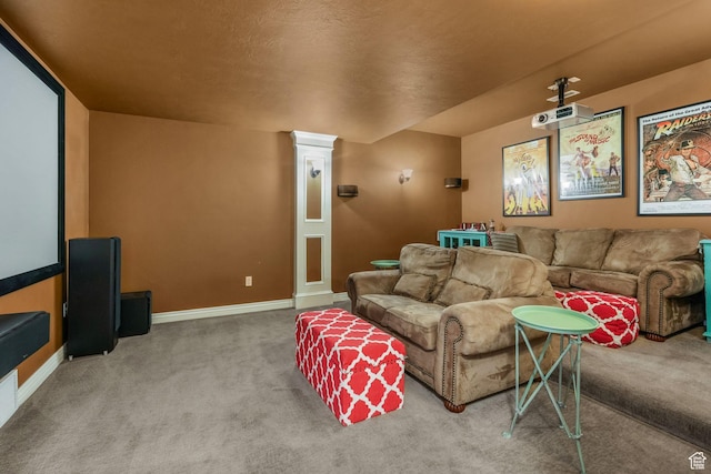 carpeted cinema room featuring baseboards