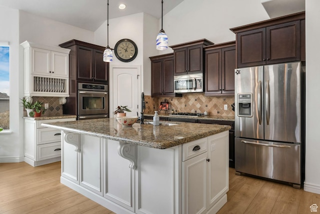 kitchen featuring dark brown cabinets, a sink, stainless steel appliances, and light wood-style flooring