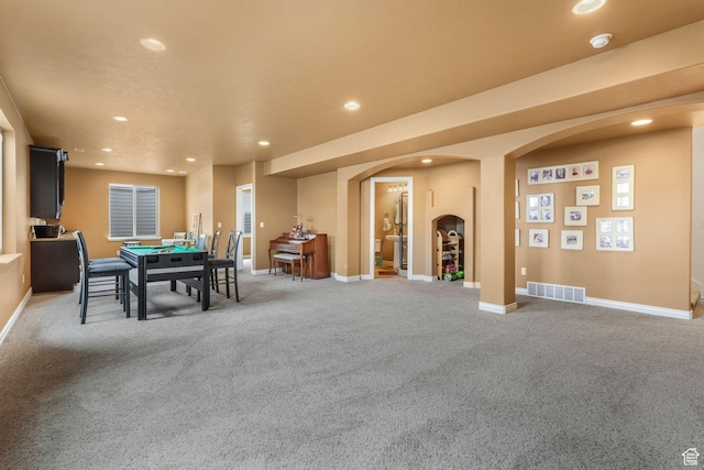 dining space with arched walkways, carpet flooring, visible vents, and recessed lighting