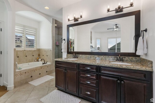 full bathroom with a garden tub, ceiling fan, a sink, and tile patterned floors