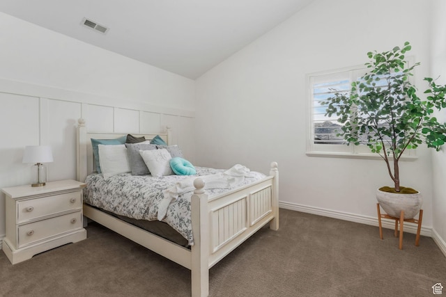 bedroom with dark carpet, baseboards, visible vents, and vaulted ceiling