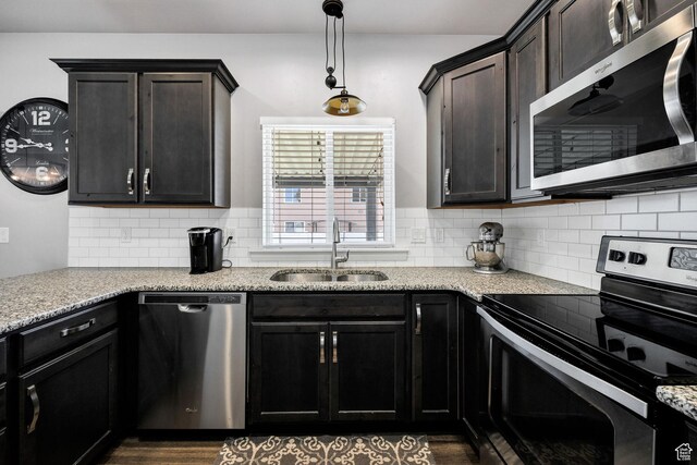 802 W 1060 S, Logan, UT 84321 - kitchen featuring tasteful backsplash, hanging light fixtures, a sink, dark brown cabinetry, and appliances with stainless steel finishes