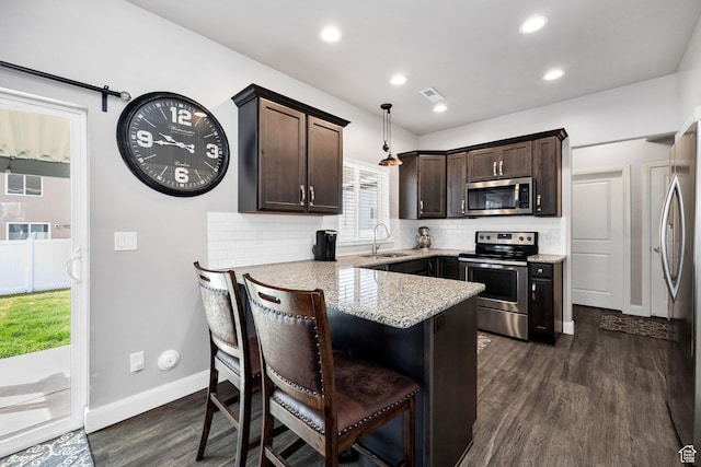 802 W 1060 S, Logan, UT 84321 - kitchen featuring dark wood-style flooring, visible vents, a peninsula, appliances with stainless steel finishes, and dark brown cabinetry